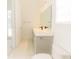 Bright bathroom featuring white marble floors, grey cabinets, and black modern fixtures at 6550 Cartmel Ln, Windermere, FL 34786