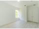 Bright bedroom featuring white walls, trim, and light-colored floors, with closet and window at 6550 Cartmel Ln, Windermere, FL 34786