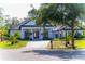 Beautiful white home featuring a circular driveway, black trim, manicured lawn, and lush landscaping at 6550 Cartmel Ln, Windermere, FL 34786