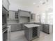 Spacious kitchen with gray cabinets, wine rack island, and stainless appliances at 6550 Cartmel Ln, Windermere, FL 34786