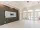 Open living room featuring decorative wall paneling, modern light fixture, and French doors at 6550 Cartmel Ln, Windermere, FL 34786