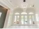 Bright living room with modern lighting, multiple french doors, and neutral-toned walls at 6550 Cartmel Ln, Windermere, FL 34786
