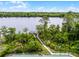 Aerial view of private dock and tennis court with a lake view surrounded by lush greenery at 889 Kensington Gardens Ct, Oviedo, FL 32765