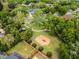 Beautiful aerial view of a community park, swings, a gazebo, and surrounding green landscape at 889 Kensington Gardens Ct, Oviedo, FL 32765