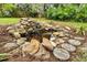 Small pond surrounded by decorative rocks and greenery with garden stones used as stepping stones at 889 Kensington Gardens Ct, Oviedo, FL 32765