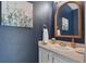 Powder room with blue walls, decorative mirror, and white vanity at 889 Kensington Gardens Ct, Oviedo, FL 32765