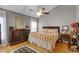 Cozy bedroom with hardwood flooring, a comfortable bed, a large dresser, and warm, neutral decor at 889 Kensington Gardens Ct, Oviedo, FL 32765