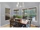 Bright dining area with a chandelier, a wooden table, and several windows providing a view of the backyard at 889 Kensington Gardens Ct, Oviedo, FL 32765