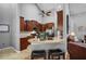Modern kitchen featuring dark wood cabinetry, stainless steel appliances, granite countertops, and bar stool seating at 889 Kensington Gardens Ct, Oviedo, FL 32765