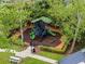 Aerial view of a modern playground with slides, climbing structures, and seating amidst lush greenery at 889 Kensington Gardens Ct, Oviedo, FL 32765