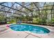 Large screened pool with outdoor seating and tropical landscaping at 889 Kensington Gardens Ct, Oviedo, FL 32765