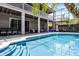 Backyard view featuring a large pool, covered patio area, and lush landscaping perfect for outdoor living at 10033 Hart Branch Cir, Orlando, FL 32832