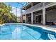 Backyard featuring an in-ground pool, covered patio, and second story deck overlooking the pool and greenery at 10033 Hart Branch Cir, Orlando, FL 32832