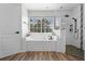 Modern bathroom with a soaking tub, sleek fixtures, and a separate shower area at 10033 Hart Branch Cir, Orlando, FL 32832