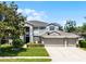 Attractive two-story house with a three-car garage, lush green lawn, and neatly trimmed shrubbery at 10033 Hart Branch Cir, Orlando, FL 32832