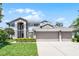 Charming two-story home with a well-maintained lawn, an inviting three-car garage, and beautifully trimmed hedges at 10033 Hart Branch Cir, Orlando, FL 32832