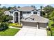 Elegant two-story home featuring a three-car garage, manicured lawn, and carefully arranged landscaping at 10033 Hart Branch Cir, Orlando, FL 32832