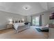 Serene primary bedroom with tray ceiling, balcony access, and plush furnishings at 10033 Hart Branch Cir, Orlando, FL 32832