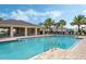 Large community swimming pool with a covered seating area, palm trees, and lounge seating at 1021 Victoria Parc Ave, Orange City, FL 32763