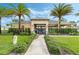 Gated community pool area with a covered seating area, palm trees, and manicured landscaping at 1021 Victoria Parc Ave, Orange City, FL 32763