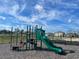 Community playground featuring a green slide, climbing structures, and park benches at 1021 Victoria Parc Ave, Orange City, FL 32763
