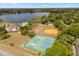 Aerial view of a community with tennis courts, baseball field and surrounding homes with mature trees at 109 Romney Marsh Rd, Longwood, FL 32779