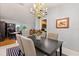 Contemporary dining room with black table, adjacent to kitchen, bright windows at 109 Romney Marsh Rd, Longwood, FL 32779