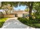 View of the exterior elevation showcasing a two-car garage, driveway, and mature landscaping at 109 Romney Marsh Rd, Longwood, FL 32779