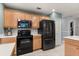 Modern kitchen features wooden cabinets, black appliances, a backsplash, and light countertops at 109 Romney Marsh Rd, Longwood, FL 32779