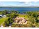 Magnificent lakefront estate with lush landscaping, red tile roof, and circular driveway at 1112 Orange Ave, Winter Springs, FL 32708
