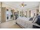 Bedroom with multiple access points to a back patio overlooking a lake, ceiling fan and tray ceiling at 1112 Orange Ave, Winter Springs, FL 32708