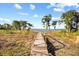 Wooden walkway leading to a dock with panoramic views of the serene lake and lush shoreline at 1112 Orange Ave, Winter Springs, FL 32708