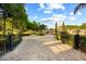 Gated entrance to property featuring manicured landscaping and brick driveway at 1112 Orange Ave, Winter Springs, FL 32708