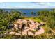 Stunning lakefront home with red tile roof, lush landscaping, and circular driveway at 1112 Orange Ave, Winter Springs, FL 32708