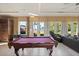A bright game room with a pool table and large windows overlooking the backyard at 1112 Orange Ave, Winter Springs, FL 32708