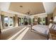 Expansive main bedroom with water views, neutral carpet and tray ceiling with three sets of french doors to exterior at 1112 Orange Ave, Winter Springs, FL 32708