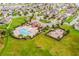 Aerial view of a community pool, playground, and clubhouse surrounded by lush green grass and homes at 12188 Ryegrass Trl, Orlando, FL 32824