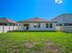 Backyard showcasing a well-maintained lawn and a view of the home's rear exterior and windows at 12188 Ryegrass Trl, Orlando, FL 32824