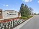 Landscaped entrance to The Reserve at Sawgrass featuring decorative brickwork and vibrant flowerbeds at 12188 Ryegrass Trl, Orlando, FL 32824