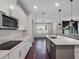 Modern kitchen with stainless steel appliances, white cabinets, a gray island and hardwood floors at 12188 Ryegrass Trl, Orlando, FL 32824