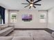 Bright living room with hardwood floors, a ceiling fan and large windows at 12188 Ryegrass Trl, Orlando, FL 32824