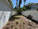 An open backyard featuring a white fence, block wall, some trees, and grass at 1236 Illinois St, Orlando, FL 32803