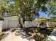 Garage and driveway with white picket fence, landscaping, and mature shade trees on a sunny day at 1236 Illinois St, Orlando, FL 32803