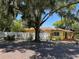 A bright yellow house with a red roof, surrounded by a white fence at 1236 Illinois St, Orlando, FL 32803