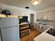 Bright kitchen featuring white cabinets and appliances, a chalkboard and hardwood floors at 1236 Illinois St, Orlando, FL 32803
