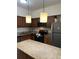 Well-lit kitchen featuring granite countertops, stainless steel appliances, and sleek dark wood cabinetry at 12539 Floridays Resort Dr Dr # 208D, Orlando, FL 32821