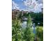 Scenic lake view of the community pool, gazebo, and multi-story buildings on a bright and sunny day at 12539 Floridays Resort Dr Dr # 208D, Orlando, FL 32821