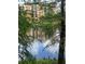 Lake view of the multi-story building reflecting in the water through the trees at 12539 Floridays Resort Dr Dr # 208D, Orlando, FL 32821