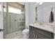 Bathroom with glass enclosed shower, dark vanity and grey tile at 13543 Abberwick Dr, Orlando, FL 32832