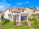 Beautiful two-story home featuring a tile roof, brick driveway, lush landscaping, and a welcoming covered entrance at 13543 Abberwick Dr, Orlando, FL 32832